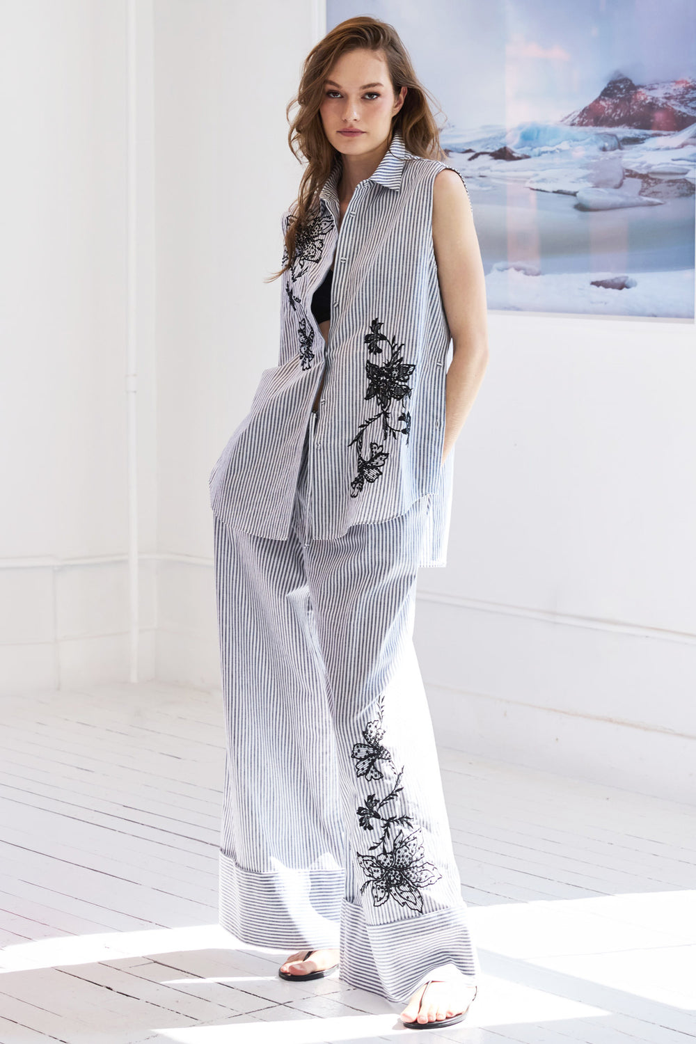 Sleeveless shirt with straight silhouette, striped cotton, embellished details at yoke; front view on model.