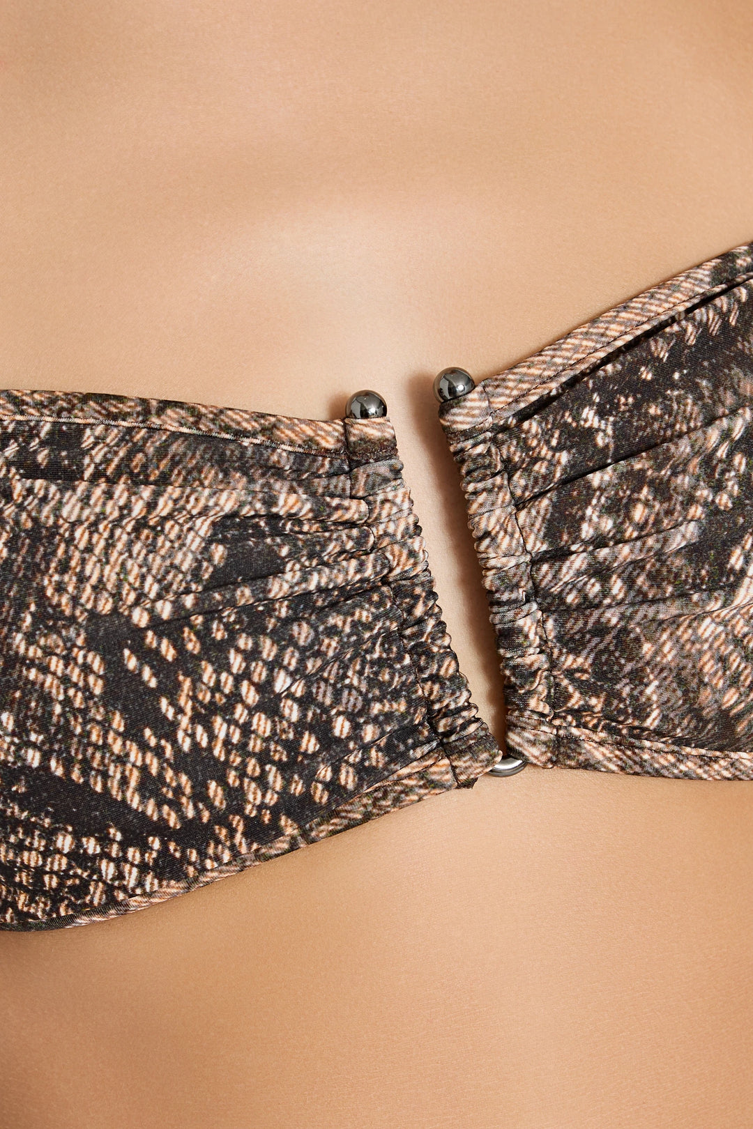 Close-up of a patterned strapless top on a beige background