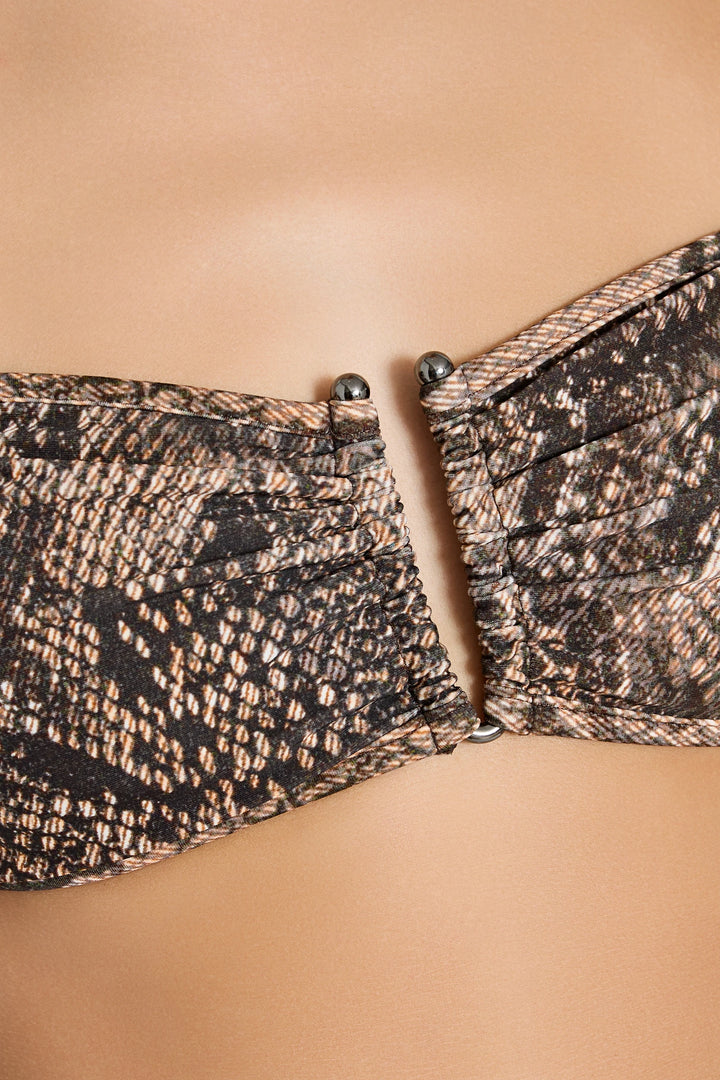 Close-up of a patterned strapless top on a beige background