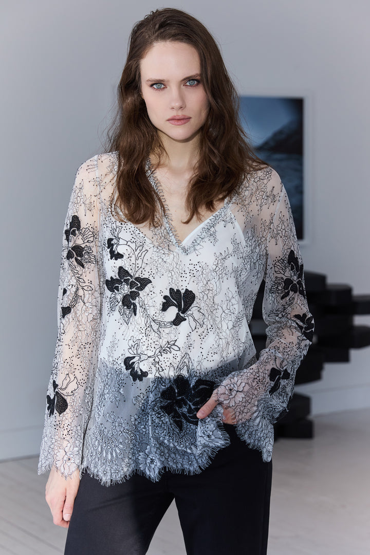 Woman wearing a floral lace top in an indoor setting