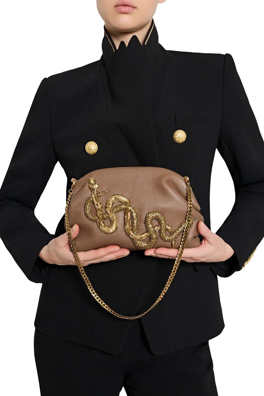 Structured snake leather clutch with gold jeweled serpent embellishment, gold chain strap; front view on model.