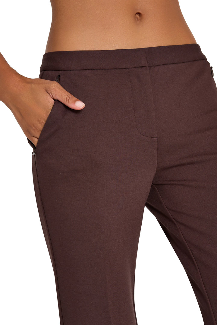 Slim, tapered knit pant with front zip pockets and fitted waist in brown; front view on model.