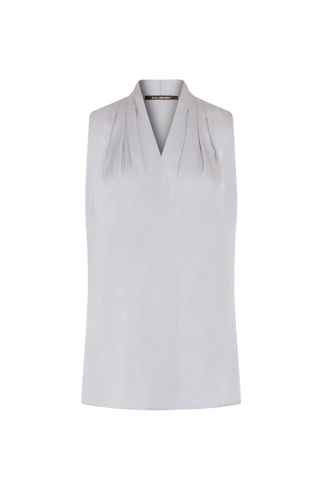 Sleeveless silk blouse with V-neck, subtle shoulder pleating; fluid silhouette. Front view on white.