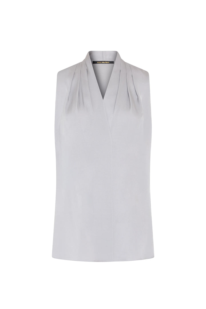 Sleeveless silk blouse with V-neck, subtle shoulder pleating; fluid silhouette. Front view on white.