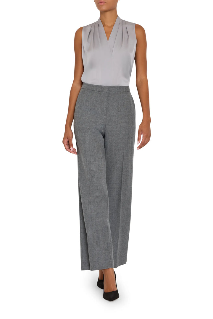 Silk blouse with relaxed silhouette, draped construction, and subtle sheen; front view on model.