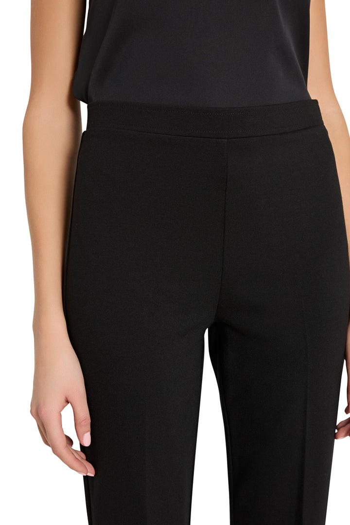 Elastic waistband, fluid silhouette, stretch knit fabric. Detail view.