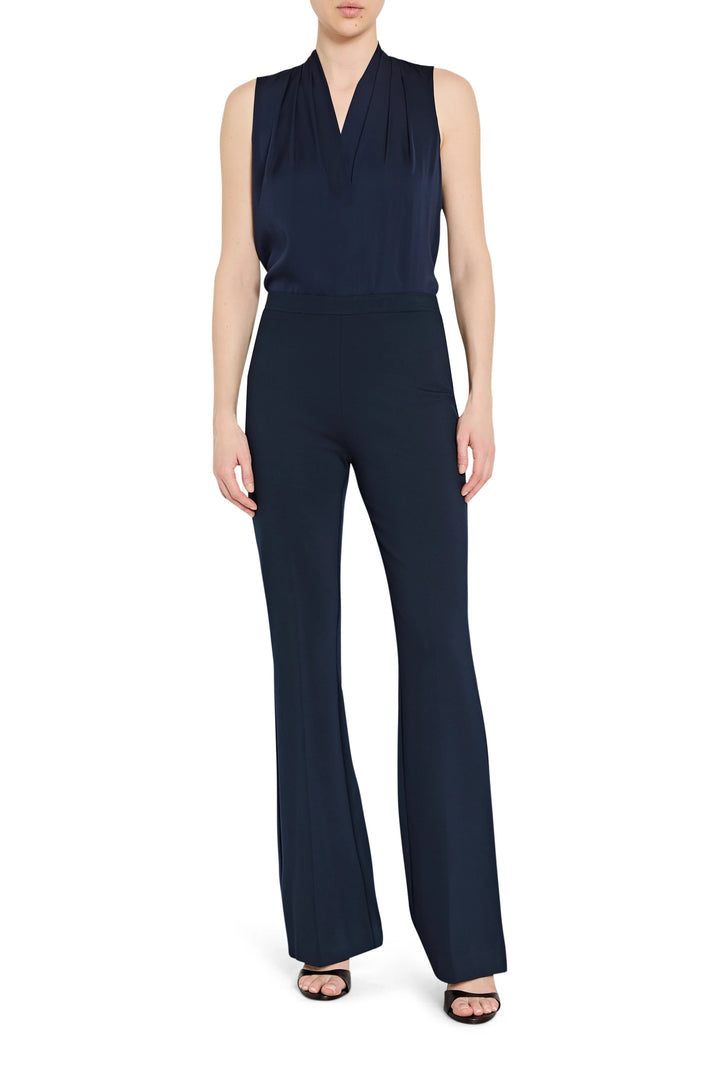 Sleeveless navy pleated blouse in flowing fabric with soft pleats and round neckline, front view on model.