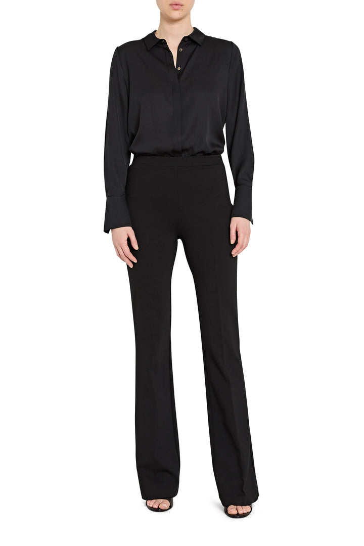 Person wearing a black long-sleeve shirt and black pants on a white background