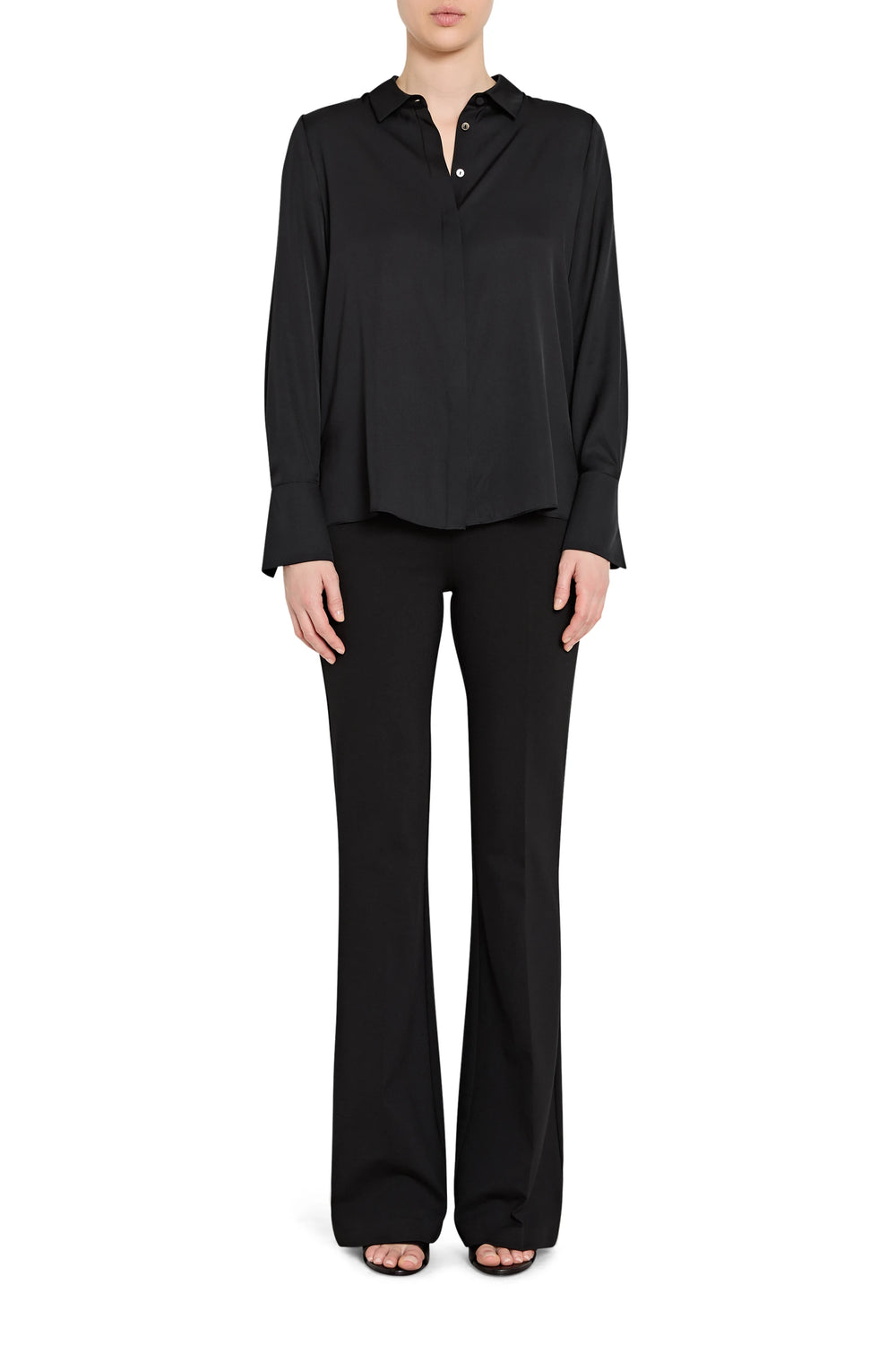 Person wearing a black long-sleeve top and black pants on a white background