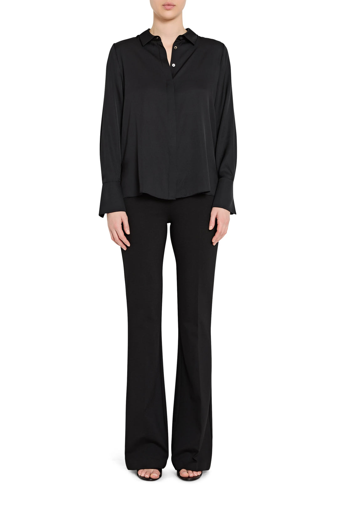 Person wearing a black long-sleeve top and black pants on a white background