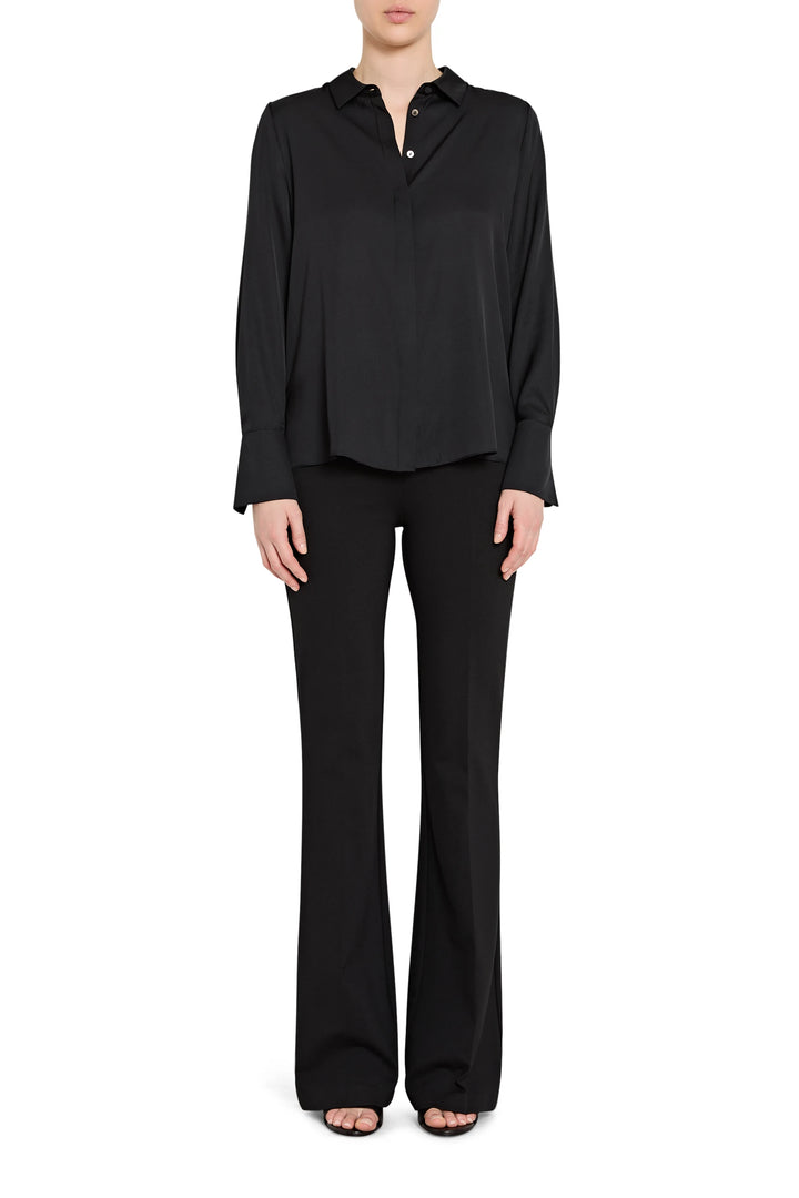 Person wearing a black long-sleeve top and black pants on a white background