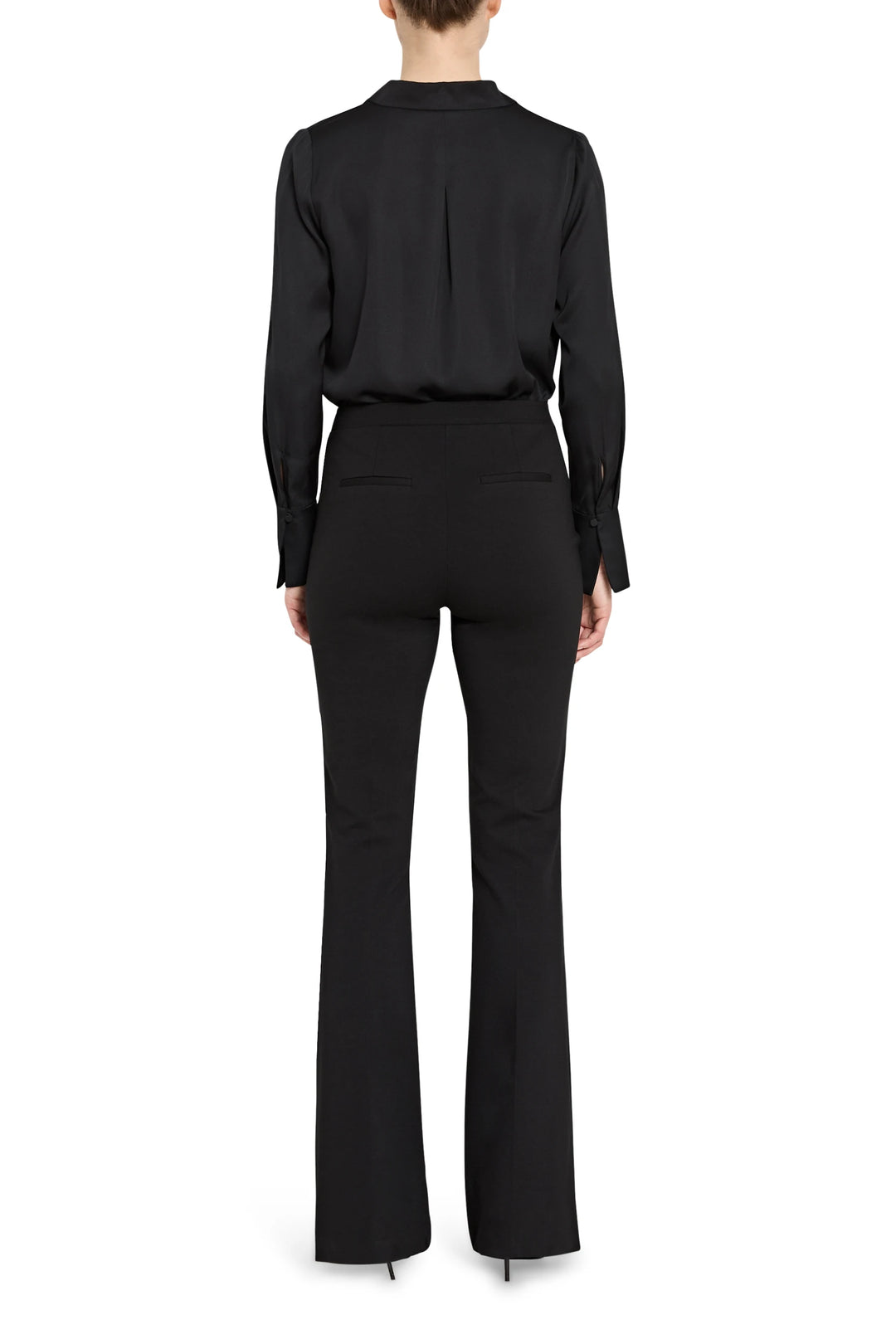 Person wearing a black outfit with a long-sleeve top and flared pants on a white background