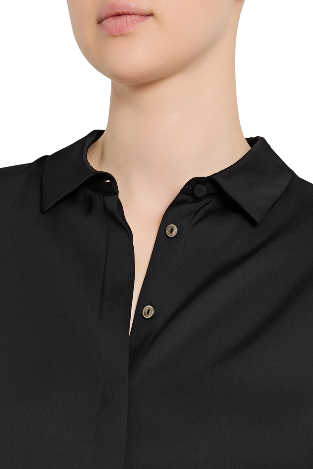 Close-up of a person wearing a black shirt with button details on a white background