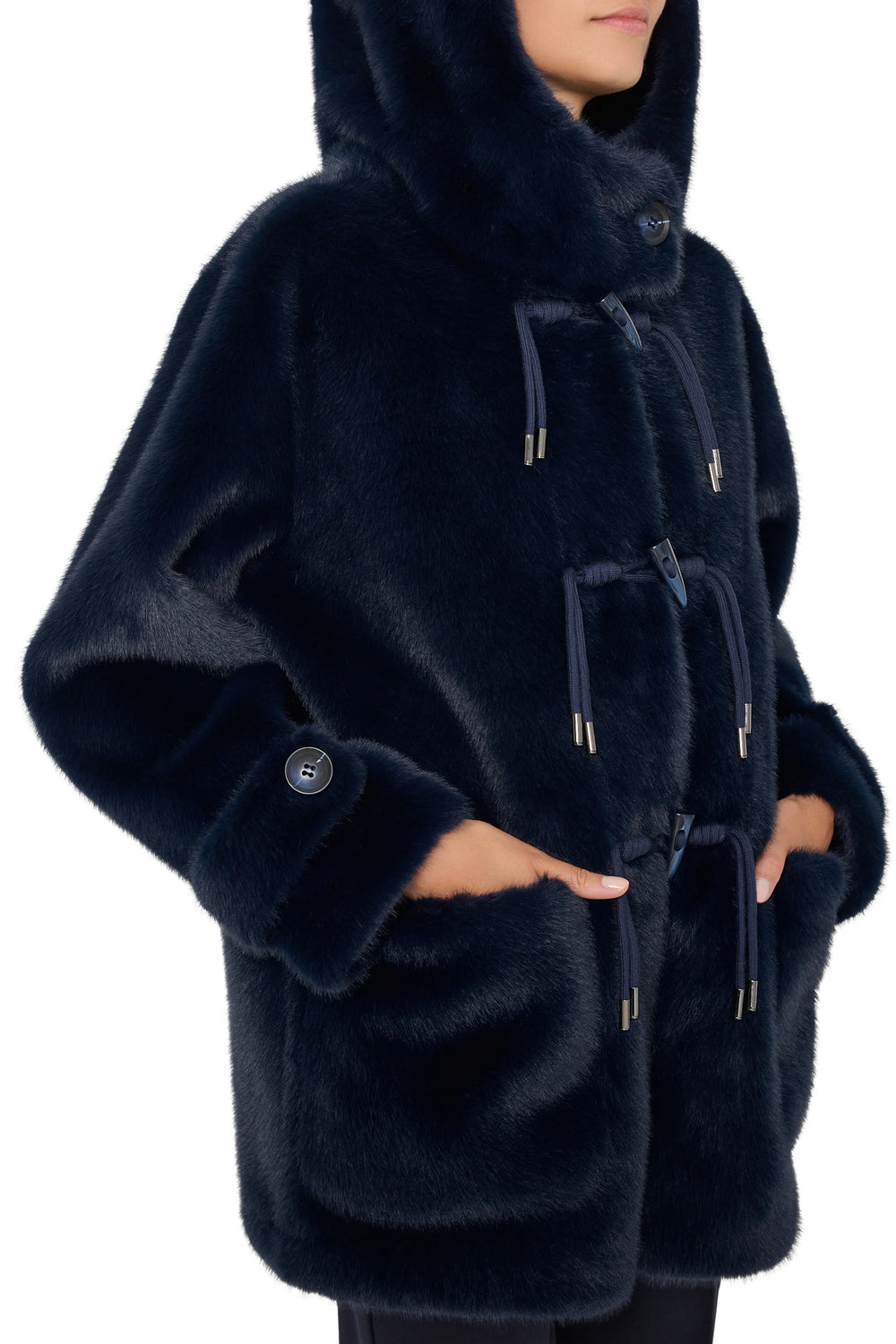 Faux fur coat with attached hood, oversized silhouette, front patch pockets. Front view on model.