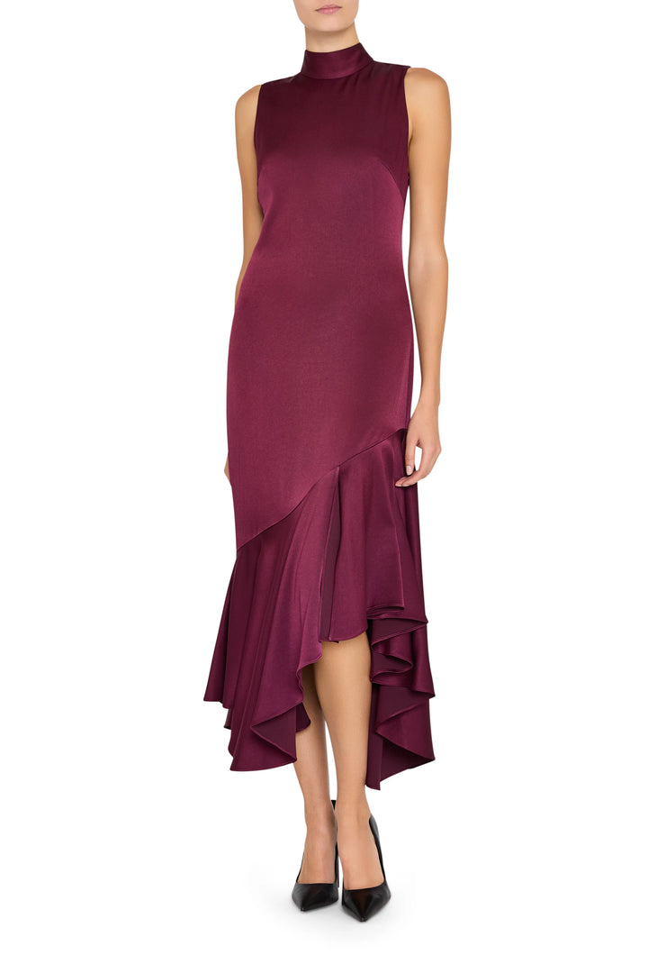 Sleeveless crepe dress with high neck, asymmetrical hem, and fluid silhouette. Front view on model.