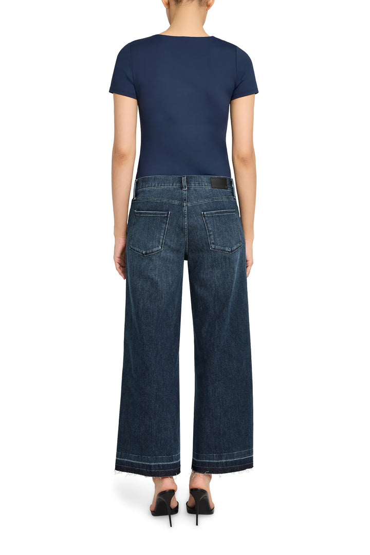 Cropped flare jean with raw-edge hem, fitted through hip and thigh; back view on model.