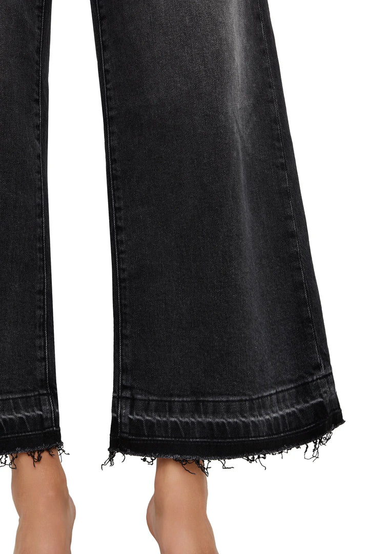 Raw-edge hem and cropped flare silhouette in denim, detailed view of lower leg construction, detail view.