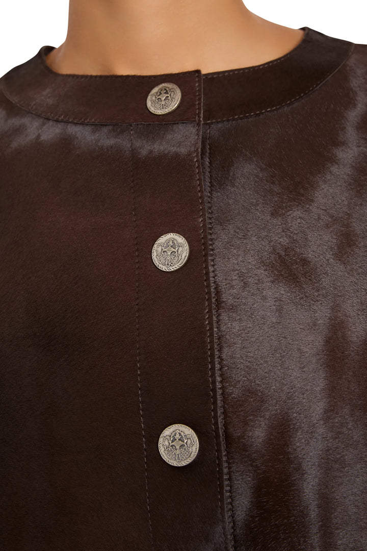 Calf pony hair fabric with ornate silver buttons and round neckline detail. Detail view.