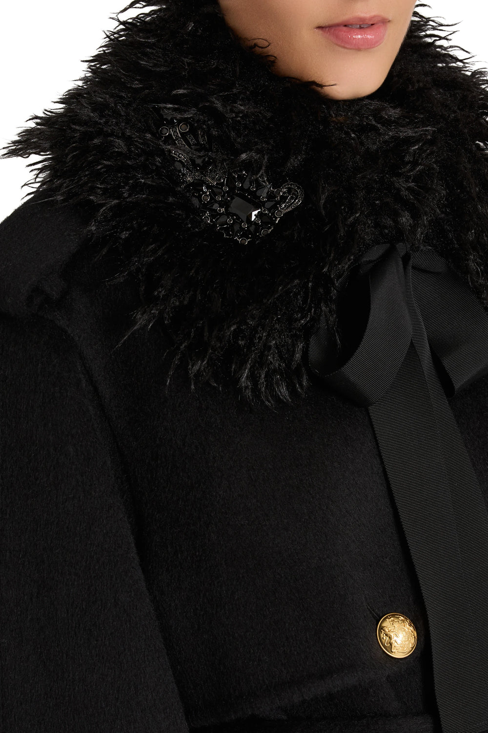 Embellished faux fur collar with black ribbon and gold button, detailed construction. Detail view.