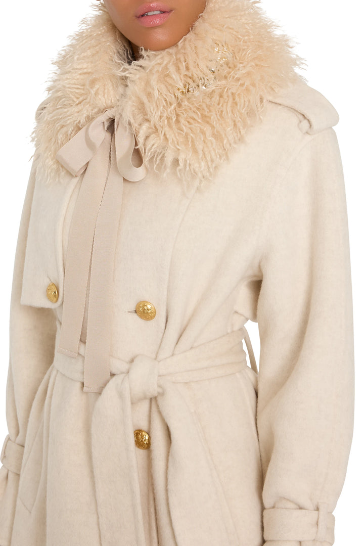 Embellished faux fur collar with gold buttons, ribbon bow, and plush texture. Front view on model.