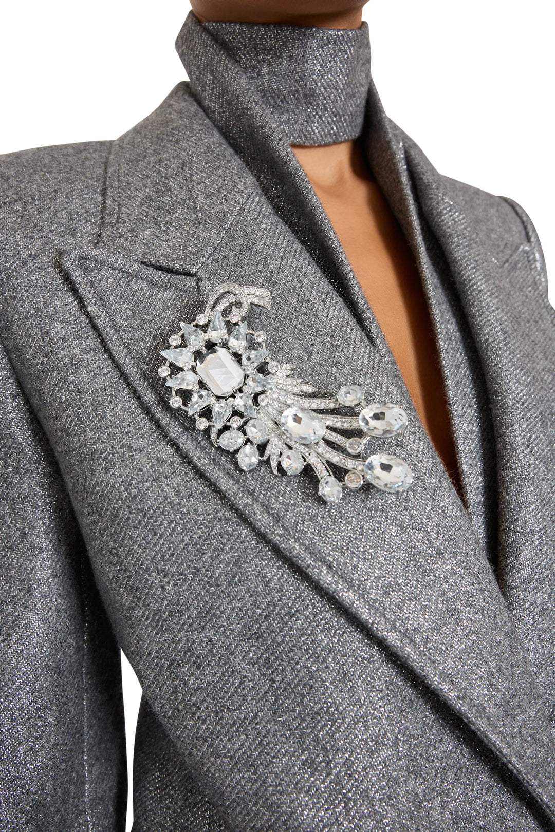 The Claude Brooch features clear gem embellishments and sculptural construction, front view on model.