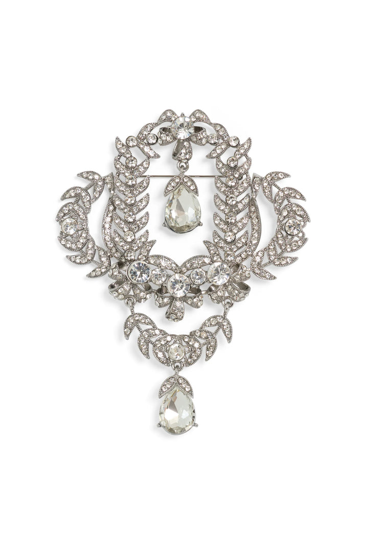 Vintage silver floral brooch, hand-embellished with clear gems, crystal teardrop pendant; front view on white.