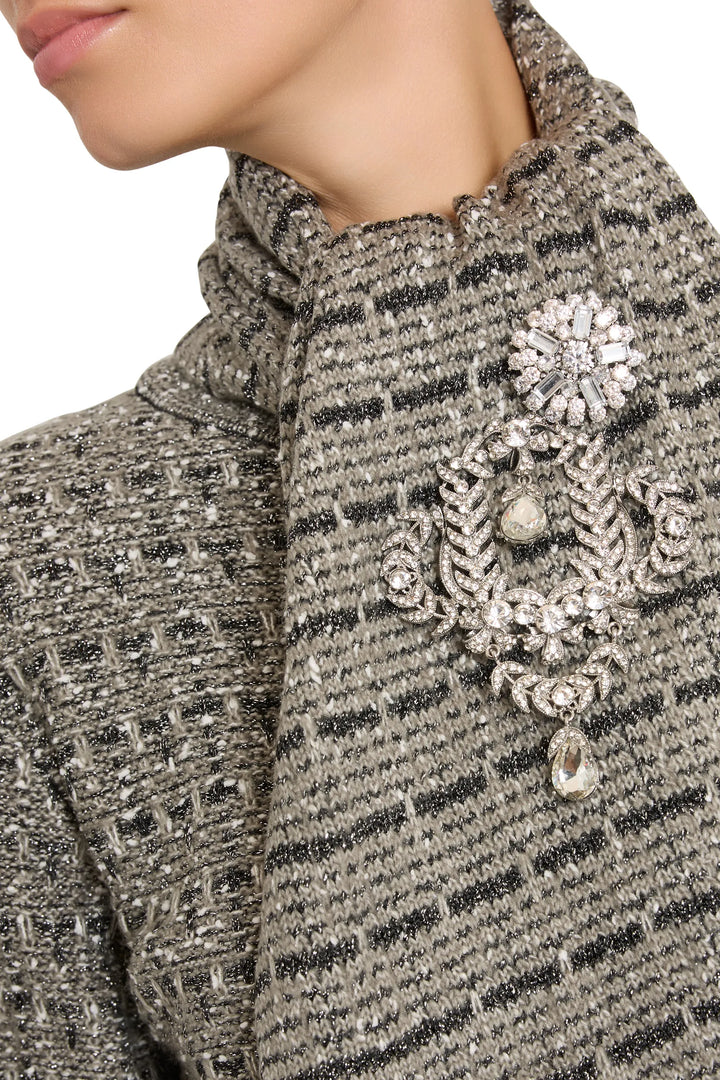 Intricate brooch with sculptural, vintage-inspired metalwork and subtle shine, detail view.