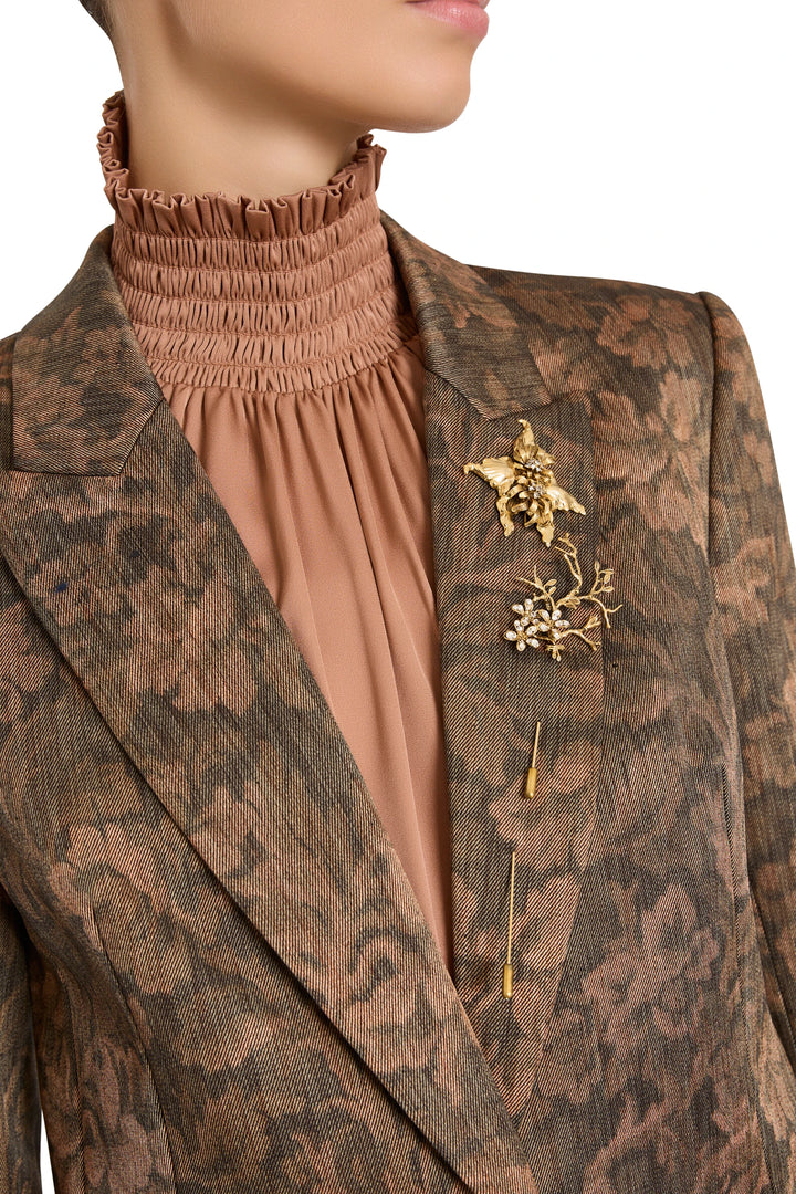 Single Bloom Pin with sculptural floral silhouette, hand-embellished petals and metallic finish, front view on model.