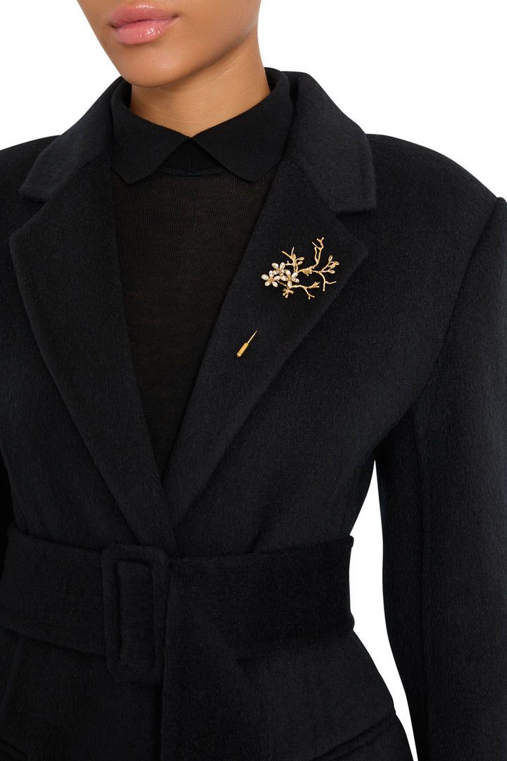 Bloom Pin, sculptural metal floral brooch with curved petals and textured finish, front view on model.