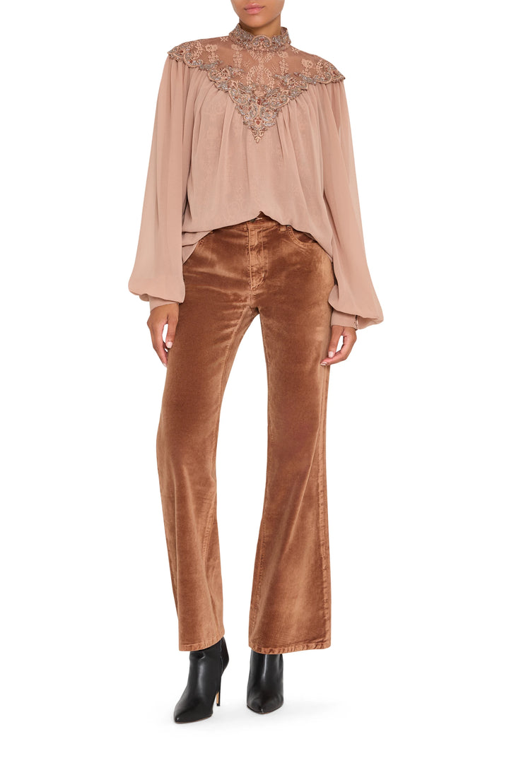 Sheer lace blouse with hand-embroidered floral details, ruffled cuffs, button-front. Front view on white.