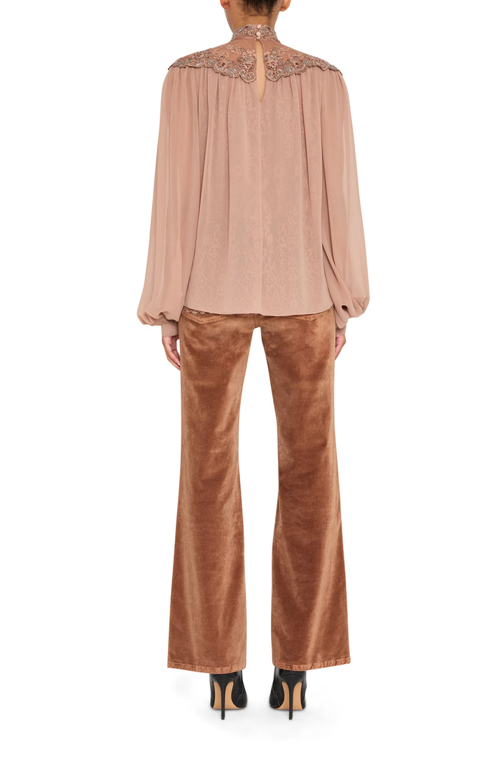 Sheer lace blouse with hand-embroidered detail, scalloped hem, and puff sleeves; front view on model.