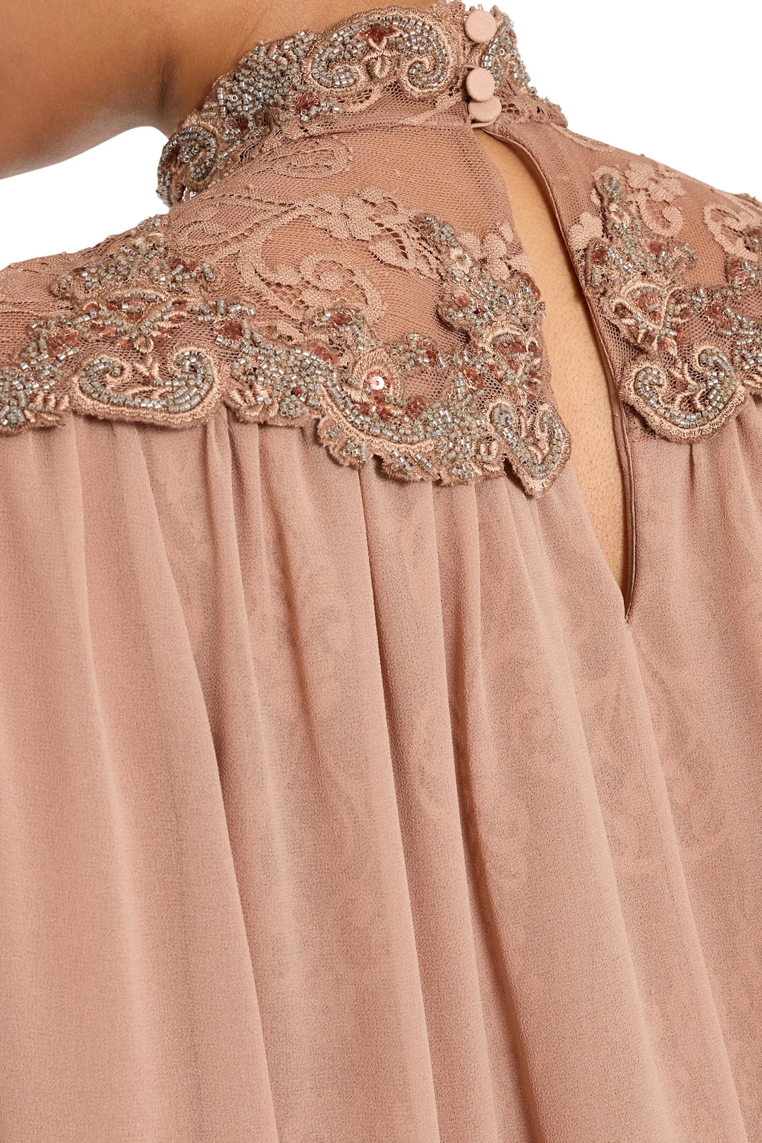 Detail of embroidered lace with seed beads and sequins along collar and neckline, detail view.