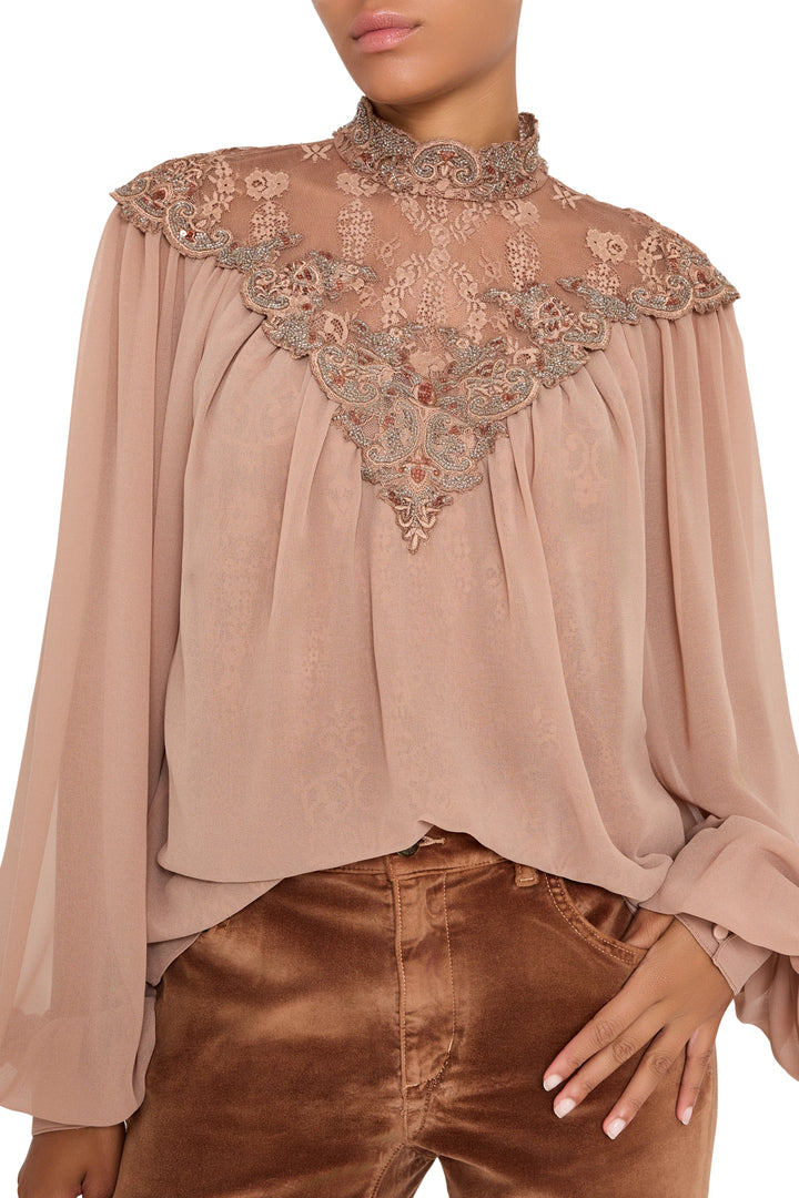 Sheer lace blouse with embroidered details, pintucked bodice, and bishop sleeves; front view on model.