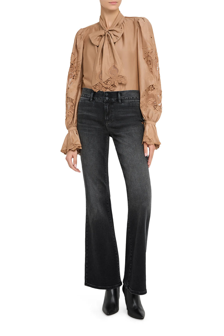 Sheer cotton blouse with hand-embroidered details, pintucked front, bishop sleeves; front view on model.