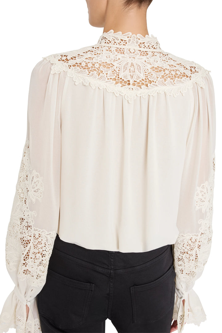 Relaxed-fit blouse with vintage-inspired embroidery, lace details, long sleeves. Front view on model.