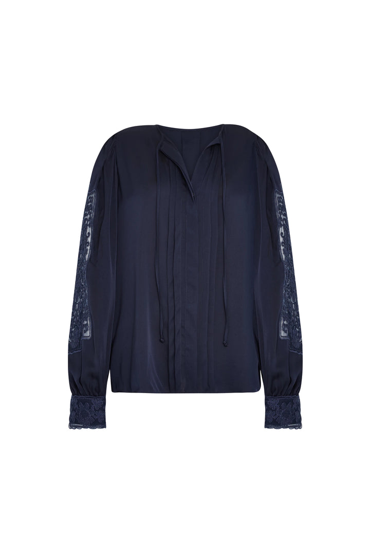 Silk blouse with lace sleeves, tie strings at collar, fluid silhouette in midnight blue. Front view on white.