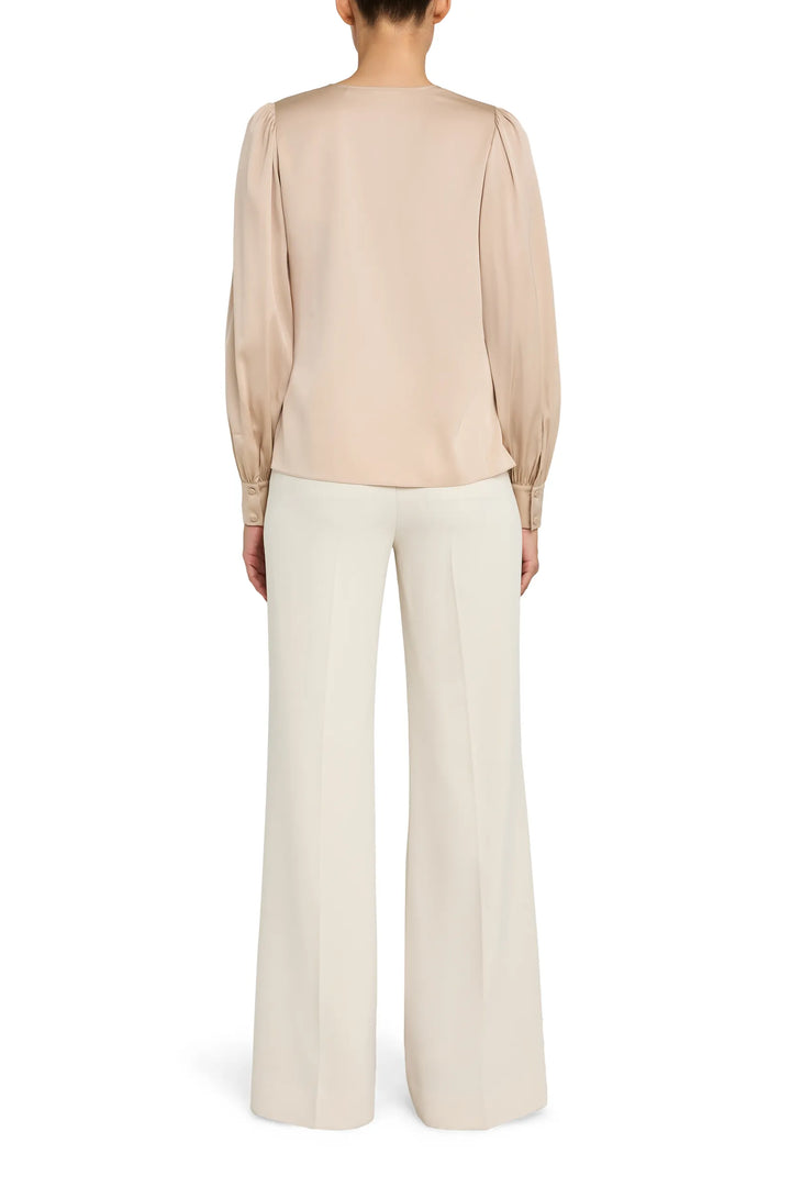 Relaxed silhouette blouse with V neckline and button front, long sleeves; back view on model.