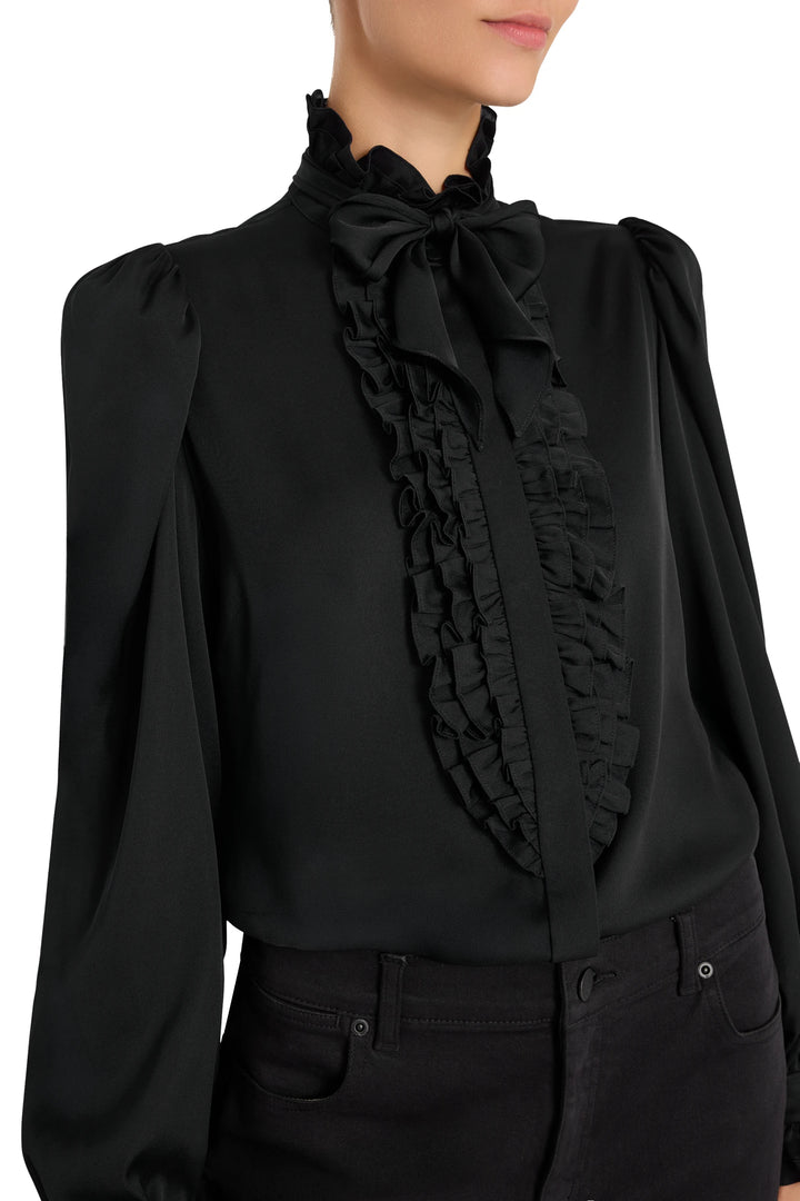 Silk blouse with ruffled bow neck and puffed sleeves, relaxed silhouette. Front view on model.