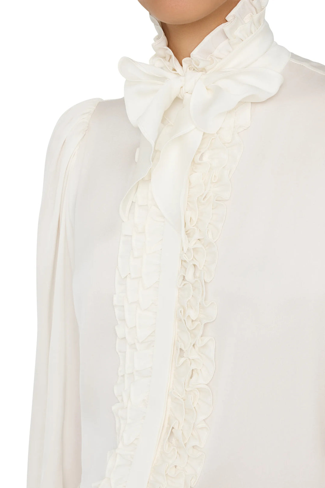 Silk blouse with romantic ruffles, bow tie neckline, relaxed fit silhouette; front view on model.