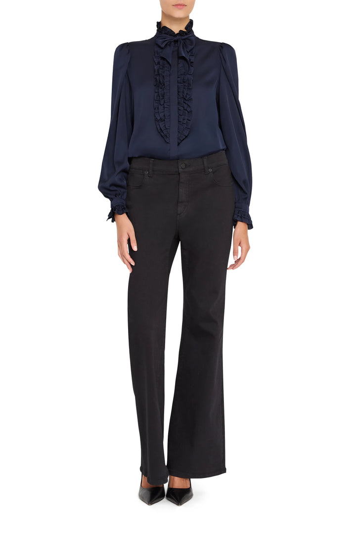 Silk blouse with ruffled front, fluid silhouette, button placket; front view on model.