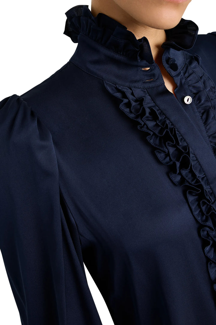 Ruffled silk blouse with button-down front and ruffled collar, tailored silhouette; front view on model.