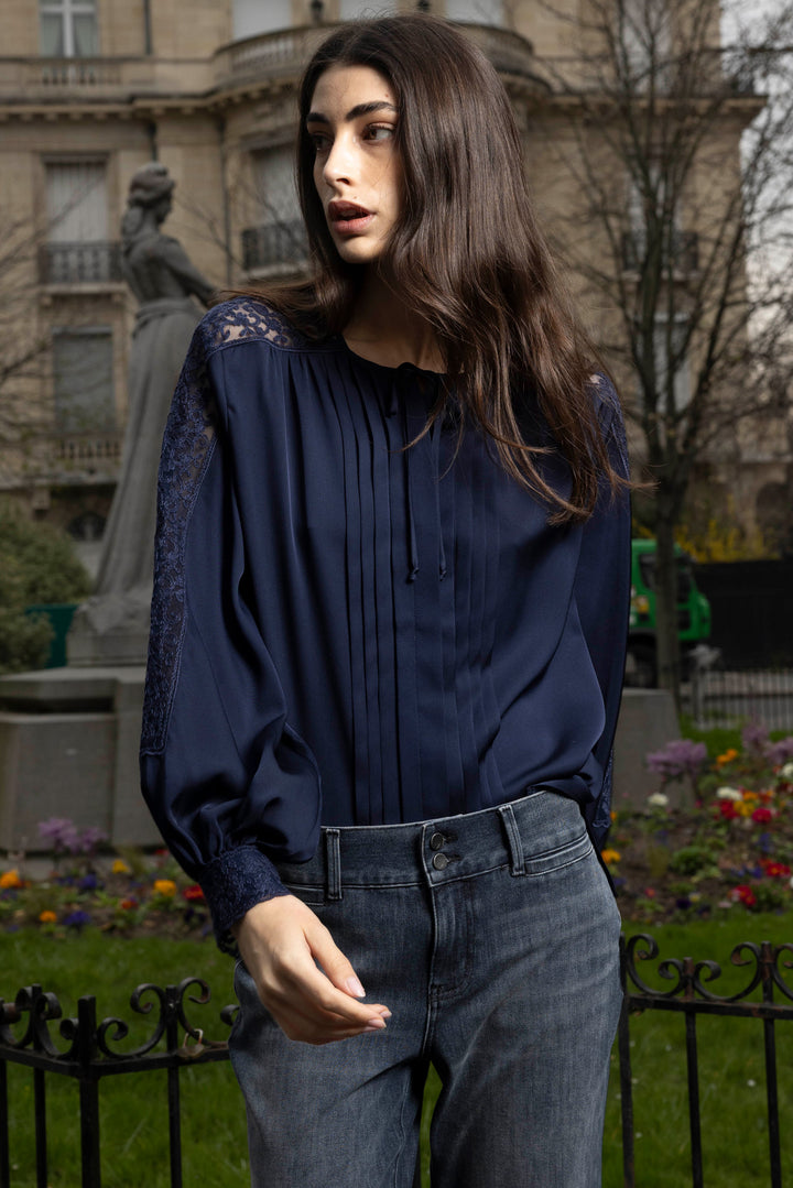 Silk blouse with ruffled neckline and sleeves, relaxed silhouette. Front view on model.
