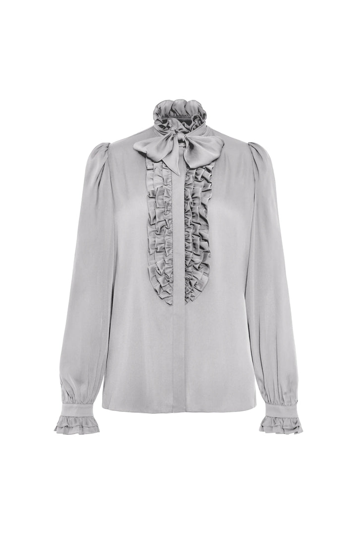 Silk blouse with ruffled front, high neck bow, and ruffled cuffs; tailored silhouette. Front view on white.