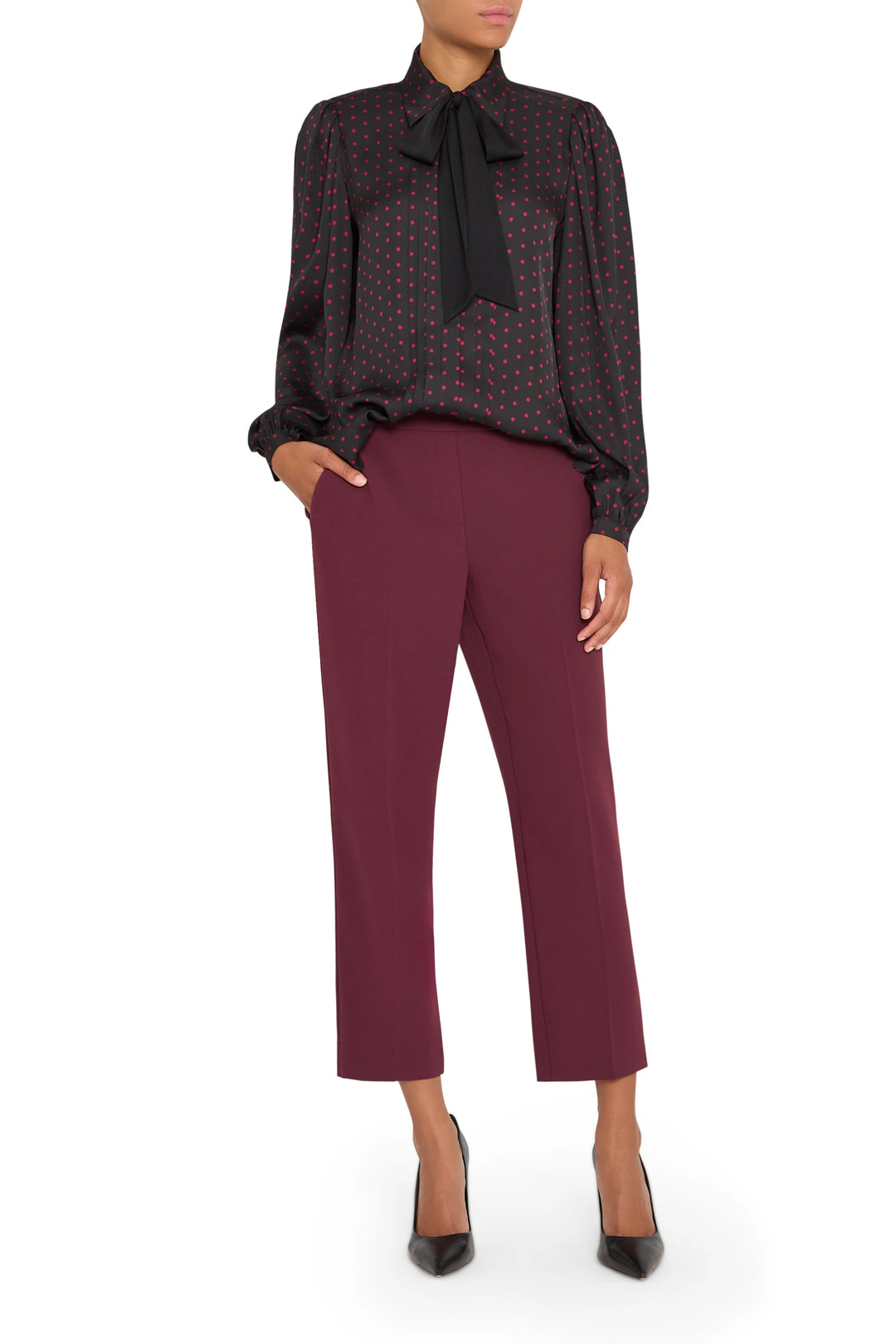 Silk polka dot blouse with tailored silhouette, button front, and slight puff sleeve; front view on model.