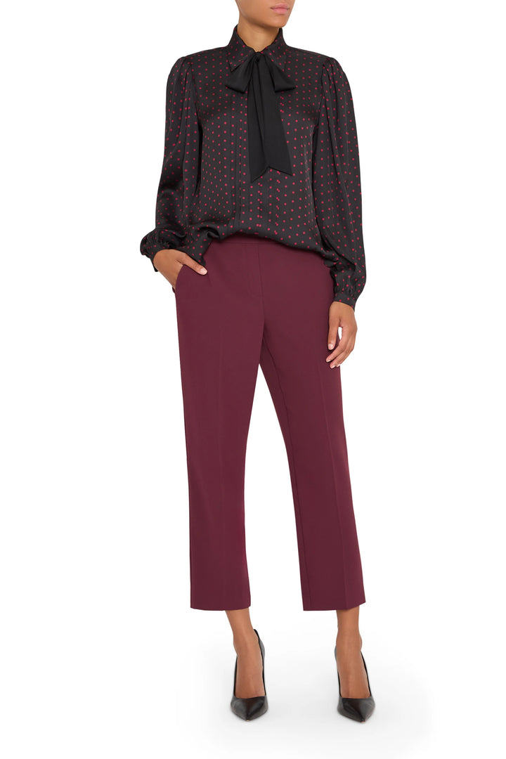 Silk polka dot blouse with tailored silhouette, button front, and slight puff sleeve; front view on model.