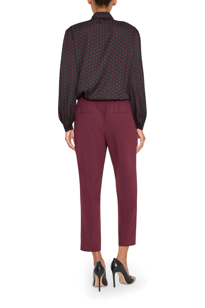 Silk polka dot blouse with relaxed fit, long sleeves, and subtle drape; back view on model.