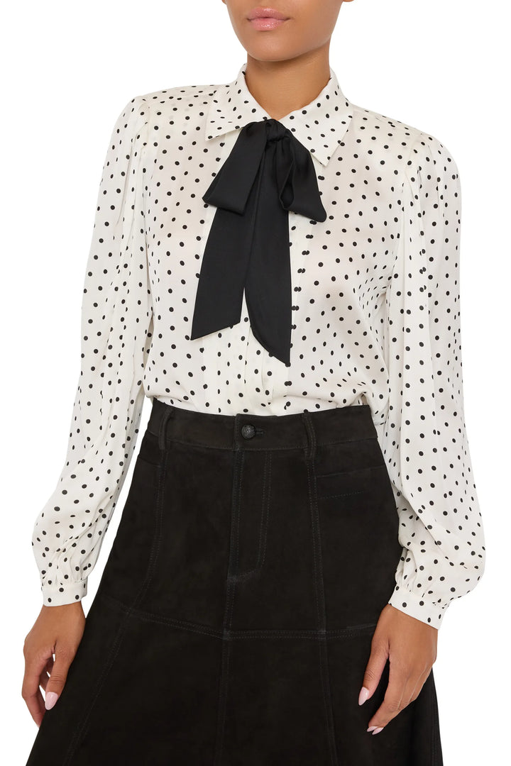 Silk blouse with structured silhouette, polka dots, removable tie, button front; front view on model.