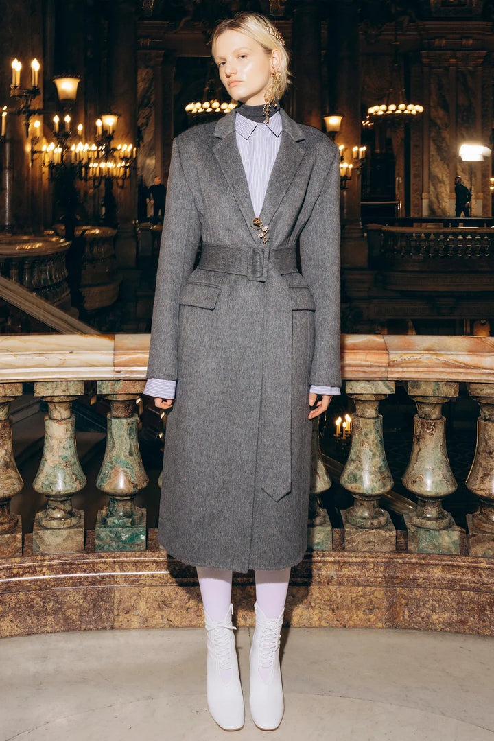 Long wool silk coat with belted waist, structured silhouette, notched lapels. Front view on model.