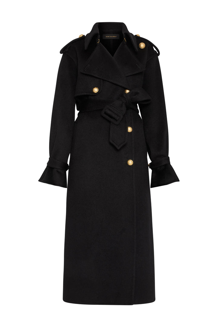 Military-inspired black trench, gold buttons, ruffled cuffs, belted waist, silk-wool. Front view on white.