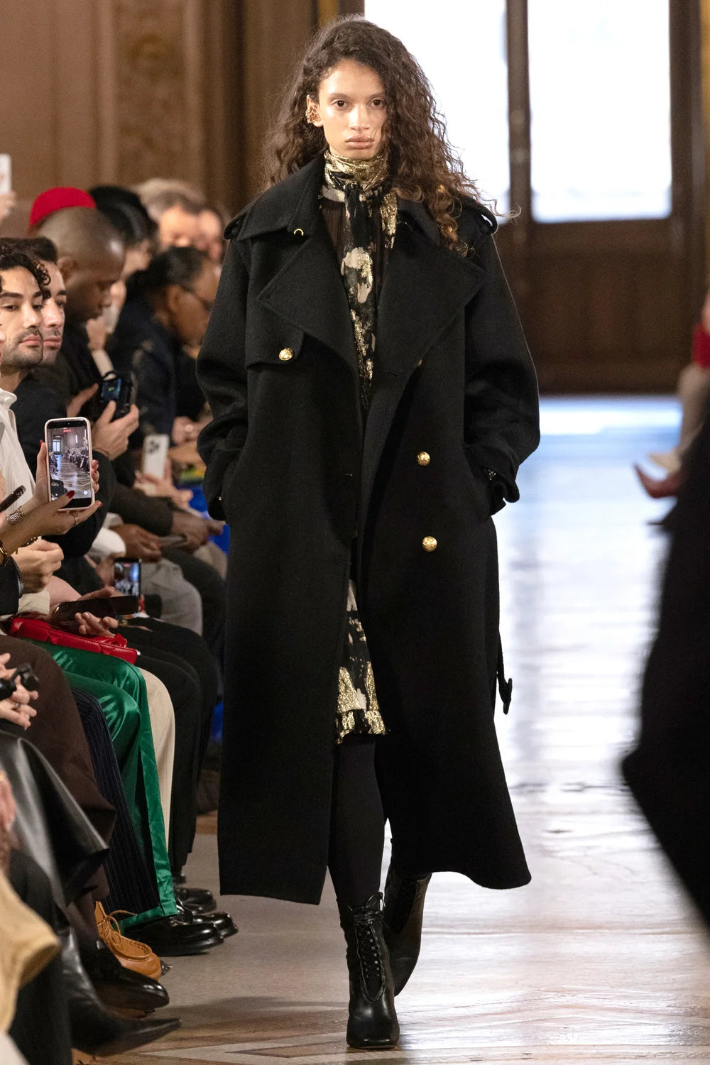 Silk wool trench coat with tailored silhouette, structured lapels, belted waist; front view on model.
